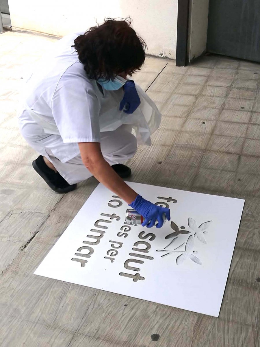 Una professional de l'equip d'atenció primària de Montmeló i Montornès pinta el missatge 'Gràcies per no fumar' a l'exterior del CAP de Montmeló