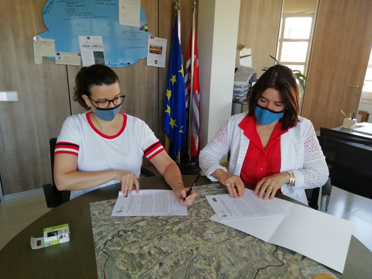 Esther Guirado i Mercè Cabanas signant l'acord
