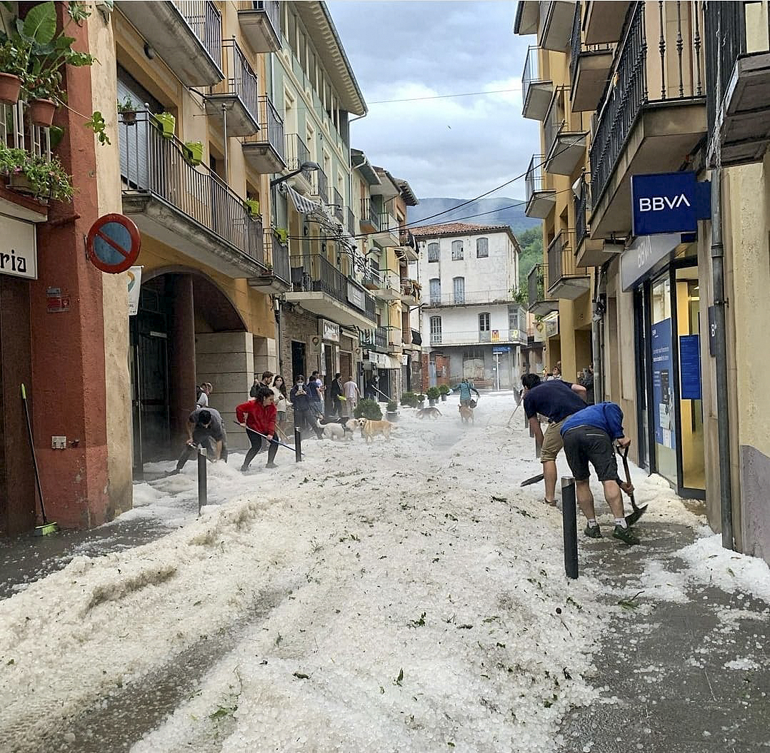 Veïns i veïnes de Ribes netejant el carrer de pedra divendres al matí