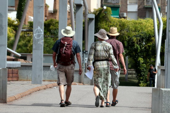 Tres turistes amb el cap cobert amb barrets a Lleida, ahir dijous