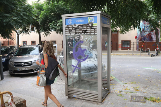 Una persona passa per davant la cabina telefònica de model tancat més antiga de Catalunya, a la ciutat de Tarragona