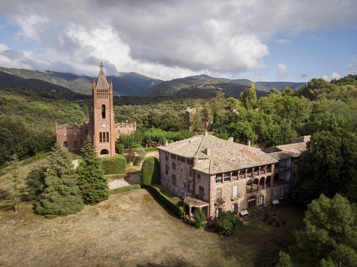 Vista de l’església, d’estil gòtic amb elements modernistes, i la casa senyorial