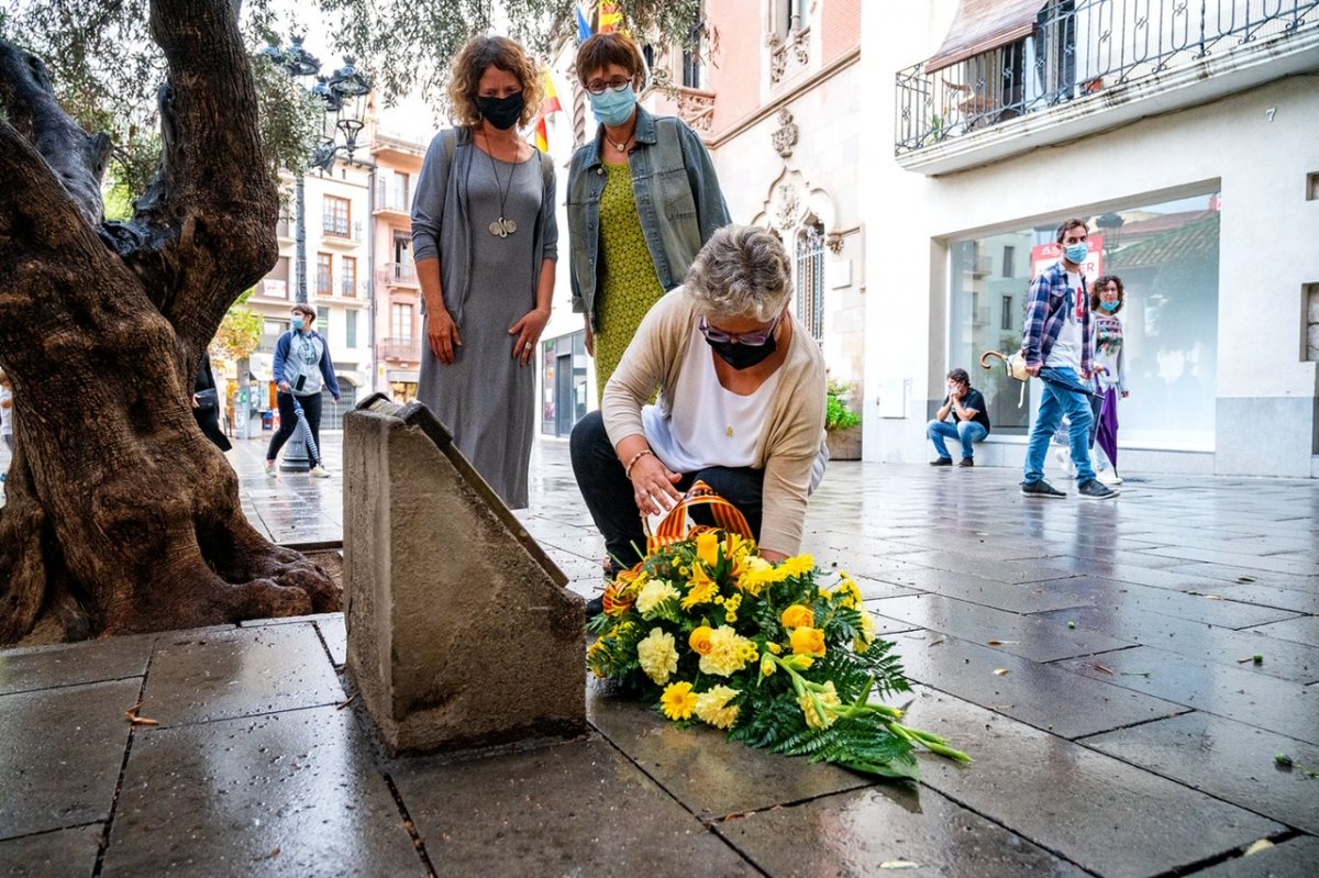 Núria Maynou diposita el ram de flors en presència de Marta Vilaret i Isabel Alcalde
