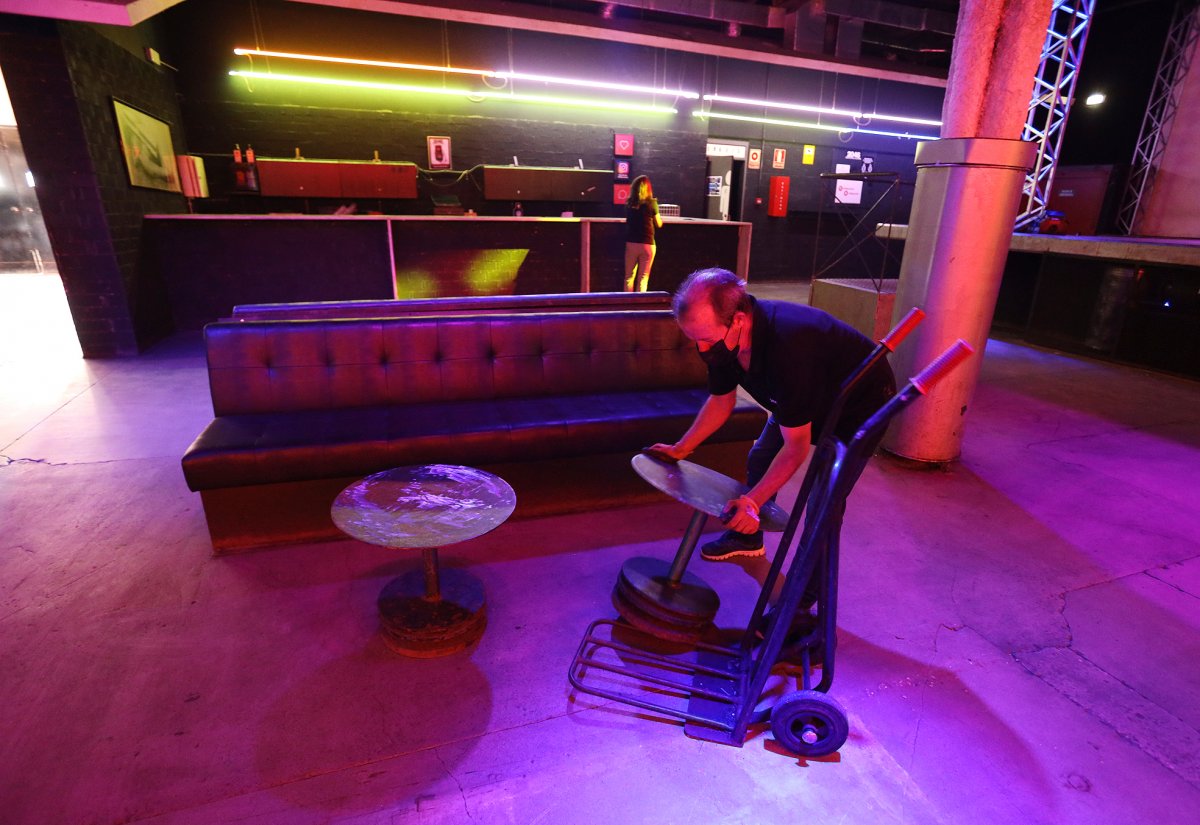 Una operari retira sofàs de la pista de ball de la sala 2046 per preparar l'obertura d'aquest divendres a la nit
