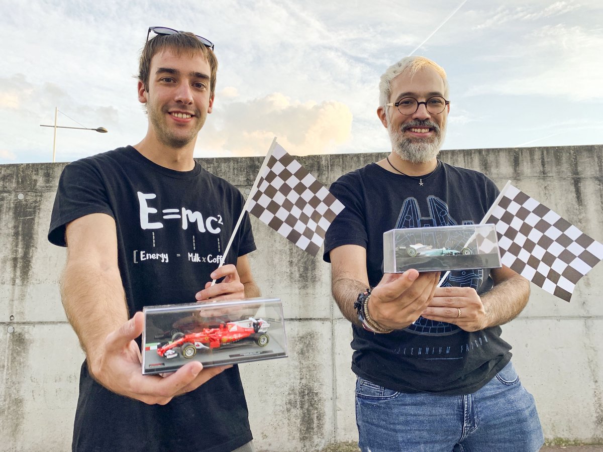 Guillem Solà Boeck i Jordi Domènech Montané, dimecres a la tarda amb dos cotxes de Fórmula 1 i les banderes de quadres típiques del món del motor