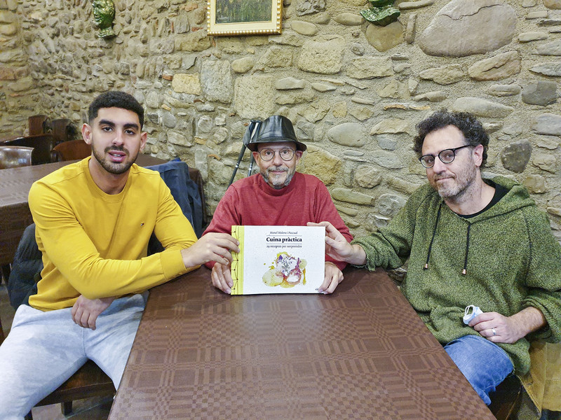 Manel Molera amb el llibre, acompanyat per Reda Benchicar, un dels joves que hi ha treballat, i Jordi Tolosa, educador