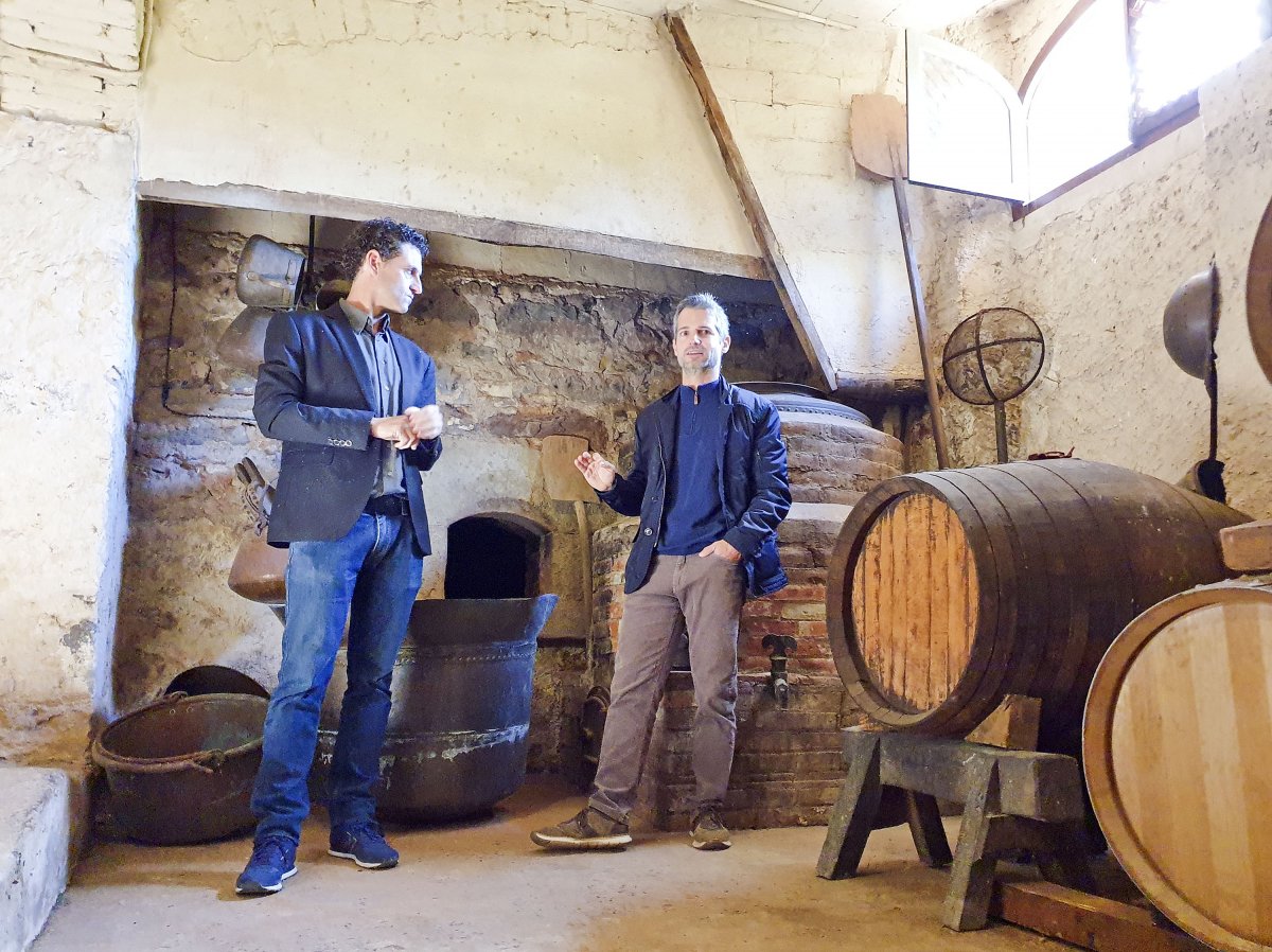 David Seijas i Ramon Roqueta, davant de l'antiga bullidora del vi bullit