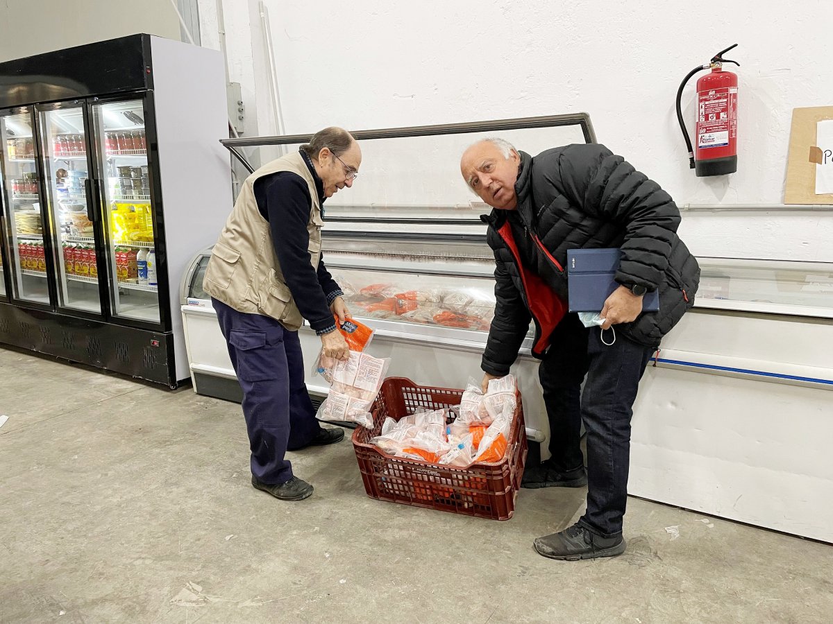 Joan Hidalgo, a la dreta, i un voluntari omplen un congelador aquesta setmana al magatzem d’El Xiprer, a les Franqueses