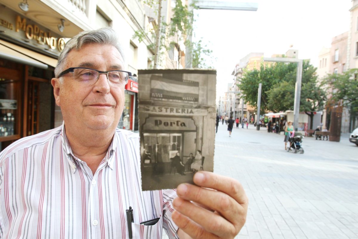 Antoni Porta amb una foto de la botiga antiga