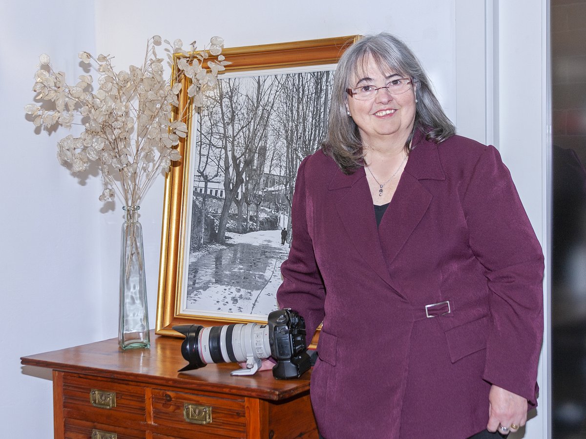 Teresa Paré davant l'escriptori del seu avi, amb una foto en blanc i negre del seu pare, on surt ella