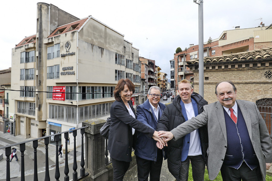 Anna Erra, Miquel Torrents, Àlex Garrido i Josep Eladi Baños fent pinya amb l'edifici que acollirà la seu de la Universitat de Vic al fons