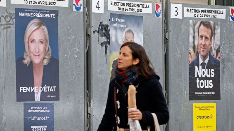 Una votant entre dos cartells electorals | GETTY IMAGES