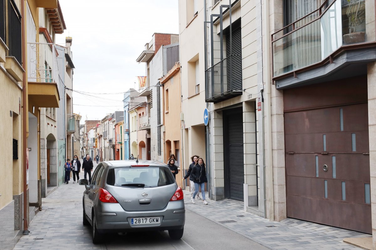 Un vehicle passant pel carrer Corró, del carrer València en direcció al centre