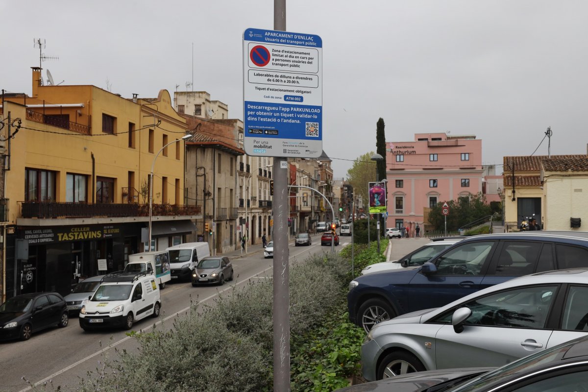 L'aparcament de l'estació de Cardedeu amb el cartell que informa del funcionament del park and ride per a usuaris de rodalies