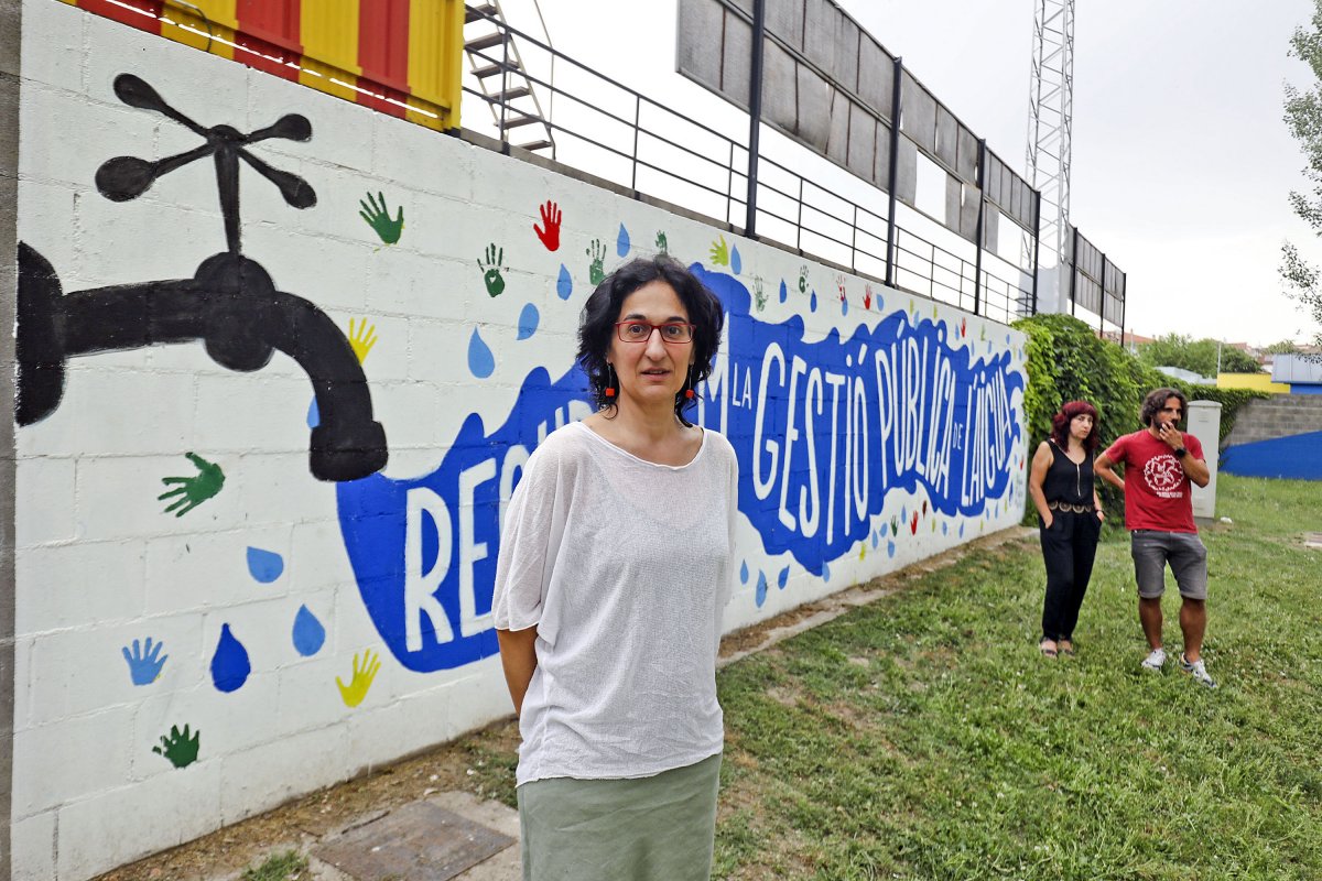 Maira Costa, en primer terme, amb altres membres de l'assemblea de la CUP a Manlleu. Van escollir el mural que advoca per la gestió pública de l'aigua com a teló de fons