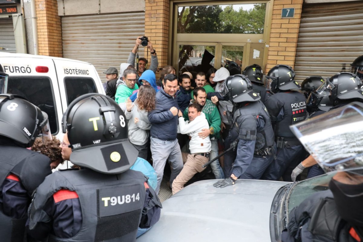 Els mossos de l'ARRO han anat retirant una a una les persones que hi havia davant de la porta del bloc