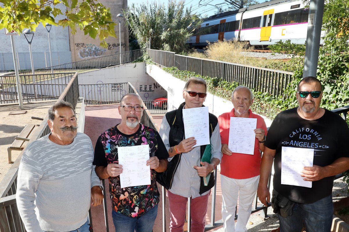 Veïns de la zona de la carretera de Ribes mostren els  fulls de la recollida de signatures