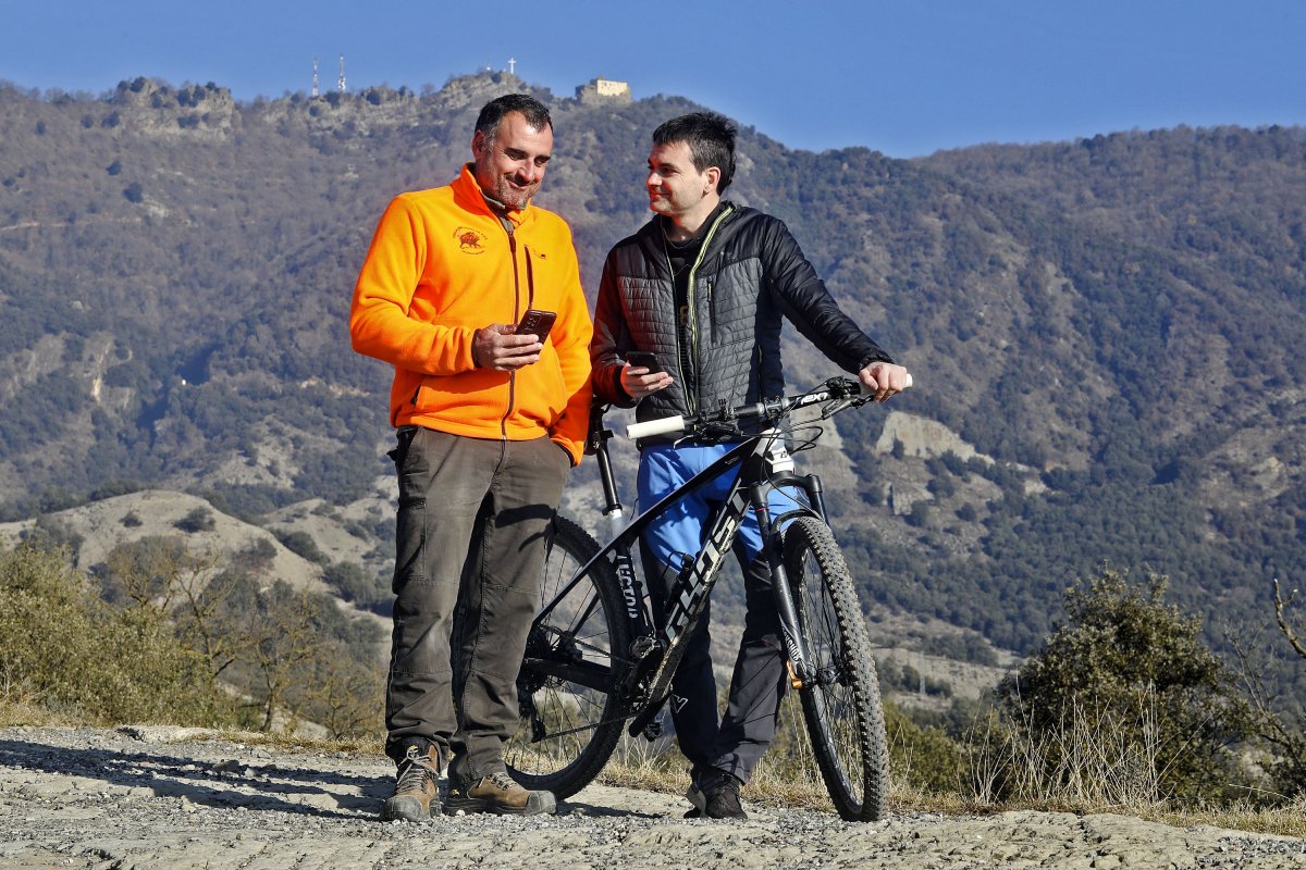 Marc Leiva, de la Societat de Caçadors de Sant Pere, i Ernest Cubí, del Centre Excursionista Serragrenyada, conversant als peus de Bellmunt
