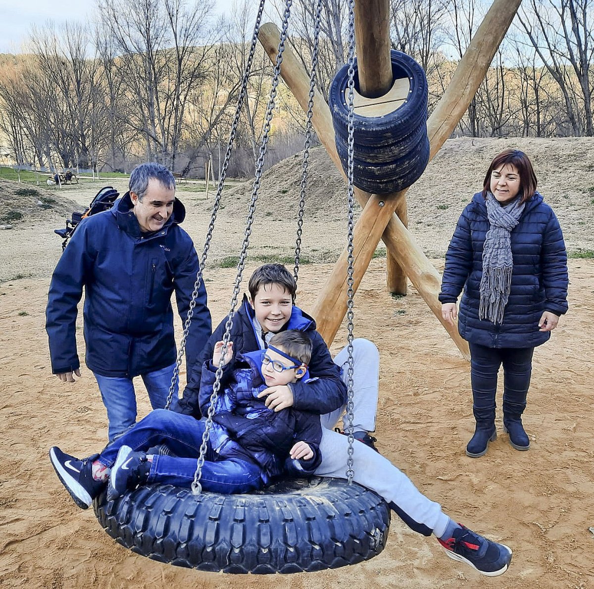 Marc Casademunt i Leticia Villazala gronxant els seus fills, l'Oriol i en Nil, al nou parc accessible i inclusiu de Montesquiu