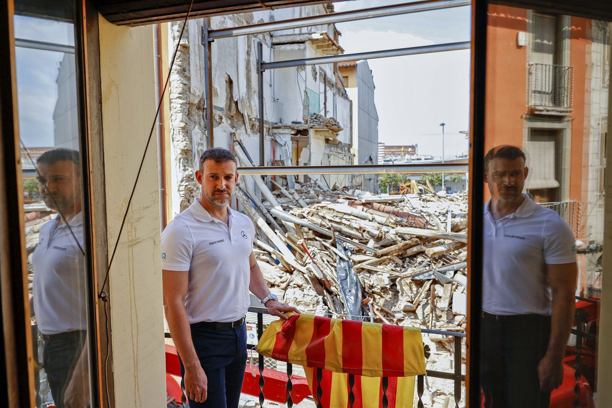 Carles Sobrino al balcó d'un veí des d'on es veuen les dues cases esfondrades al carrer Nou de Vic