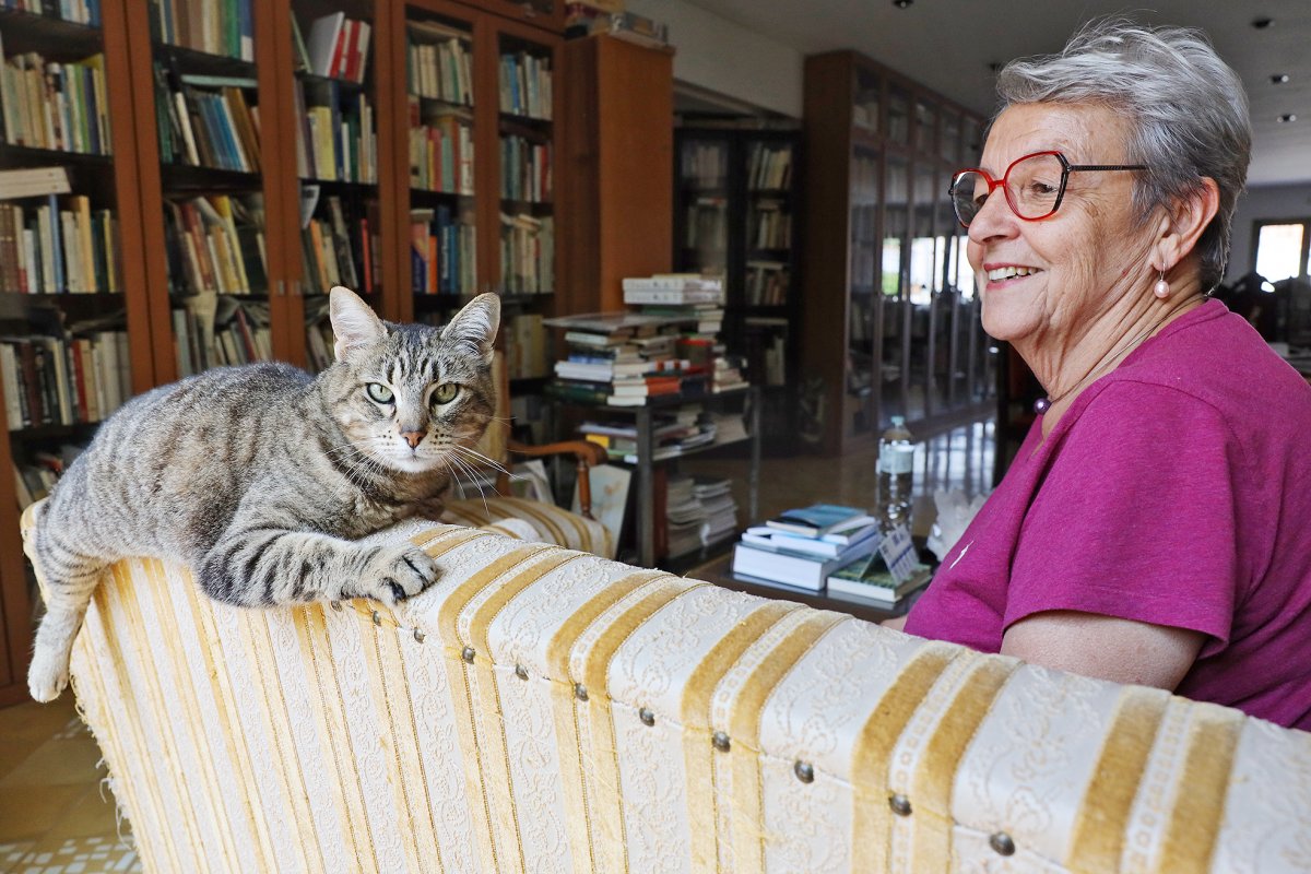 Rosa Martí, a la biblioteca de casa seva amb la seva gata Minuxa. Un dels seus objectius és endreçar la seva biblioteca