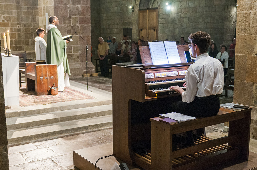 L’organista Robert Ramírez, interpretant les primeres notes amb el nou orgue, mentre el rector de Sant Joan oficiava la missa diumenge al migdia