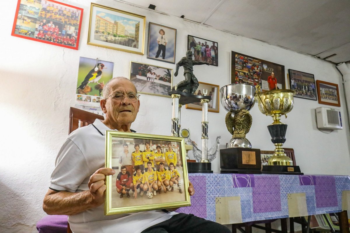Antonio Hernández, al garatge de casa seva amb trofeus i una foto de l'equip de La Bomba