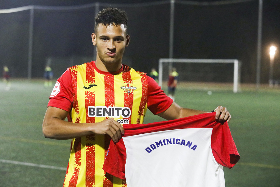Jiménez, amb els colors del Tona i mostrant una samarreta de la selecció de la República Dominicana de futbol
