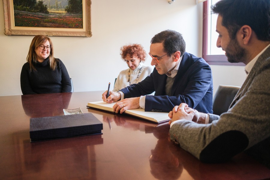 El notari Fausto Revert signant el llibre d'honor de l'Ajuntament de Manlleu durant l'acte de comiat organitzat pel consistori