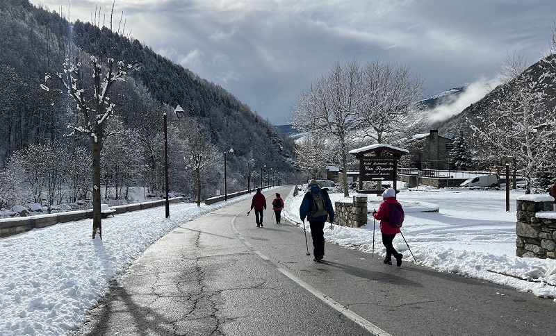 Persones passejant per Setcases en un paisatge de neu