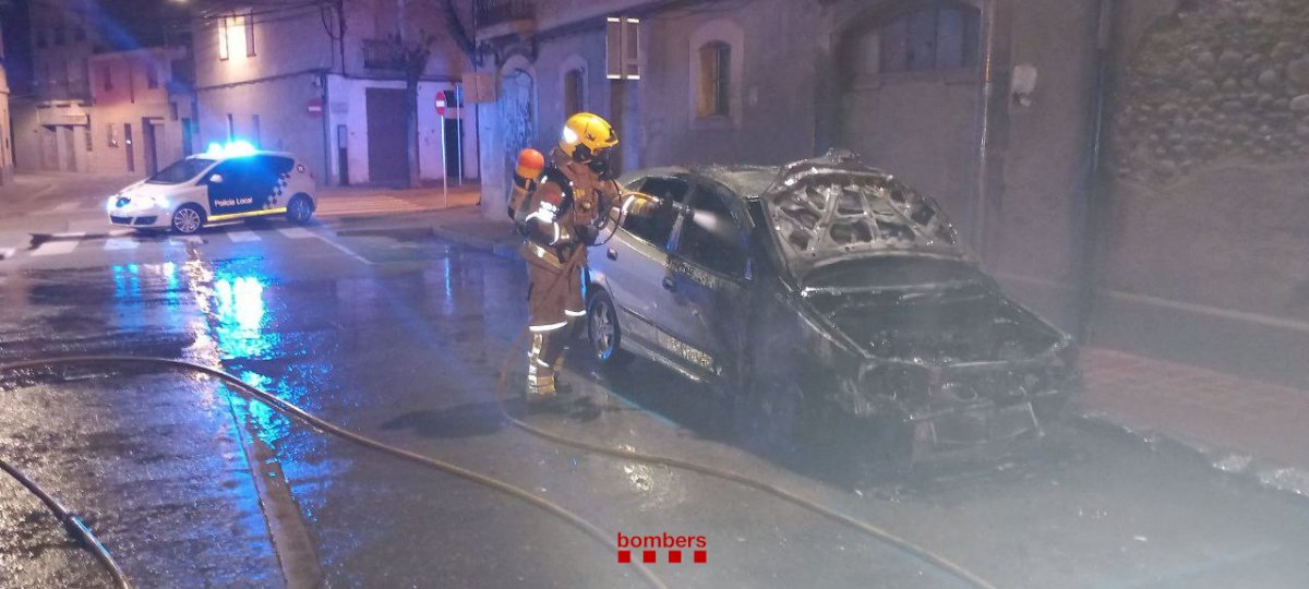Un bomber apagant el foc del cotxe