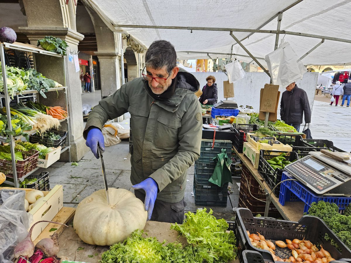 Rafel Raurell, la setmana passada a la parada del mercat setmanal dels dimarts, tallant una de les últimes carbasses del ferro de la temporada; per ell és habitual vendre-la a talls