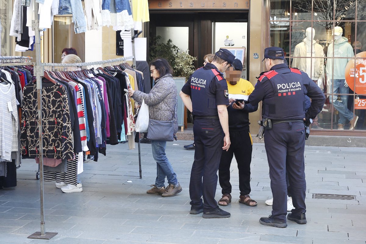 Dos mossos de l'ORC fent una identificació al mercat