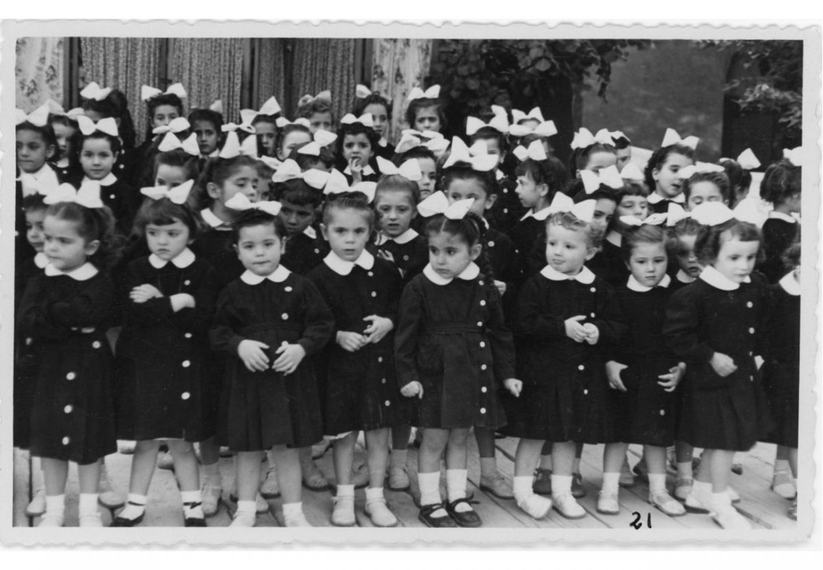 Imatge de les alumnes amb bata negra. A principis dels anys seixanta es va substituir la bata per un pitxi blau fosc