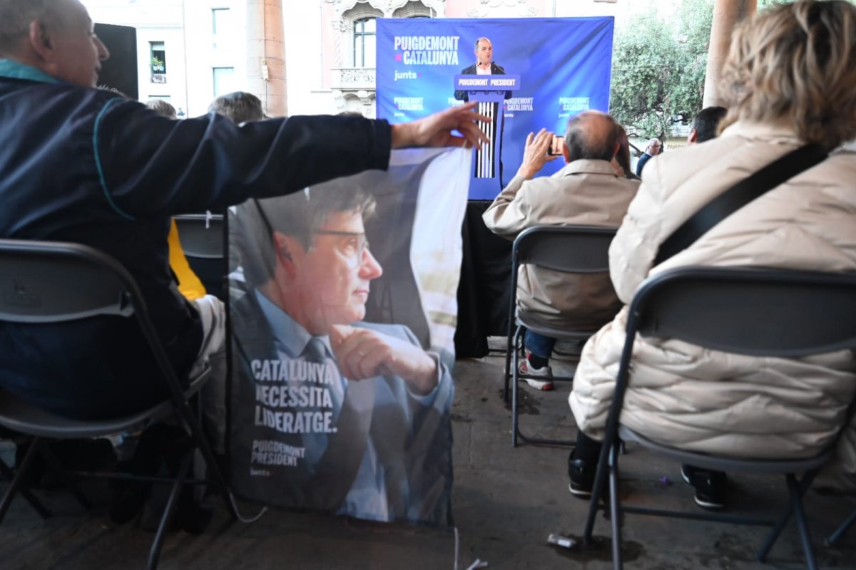 Un participant en l'acte sosté un cartell de Puigdemont mentre parla Turull