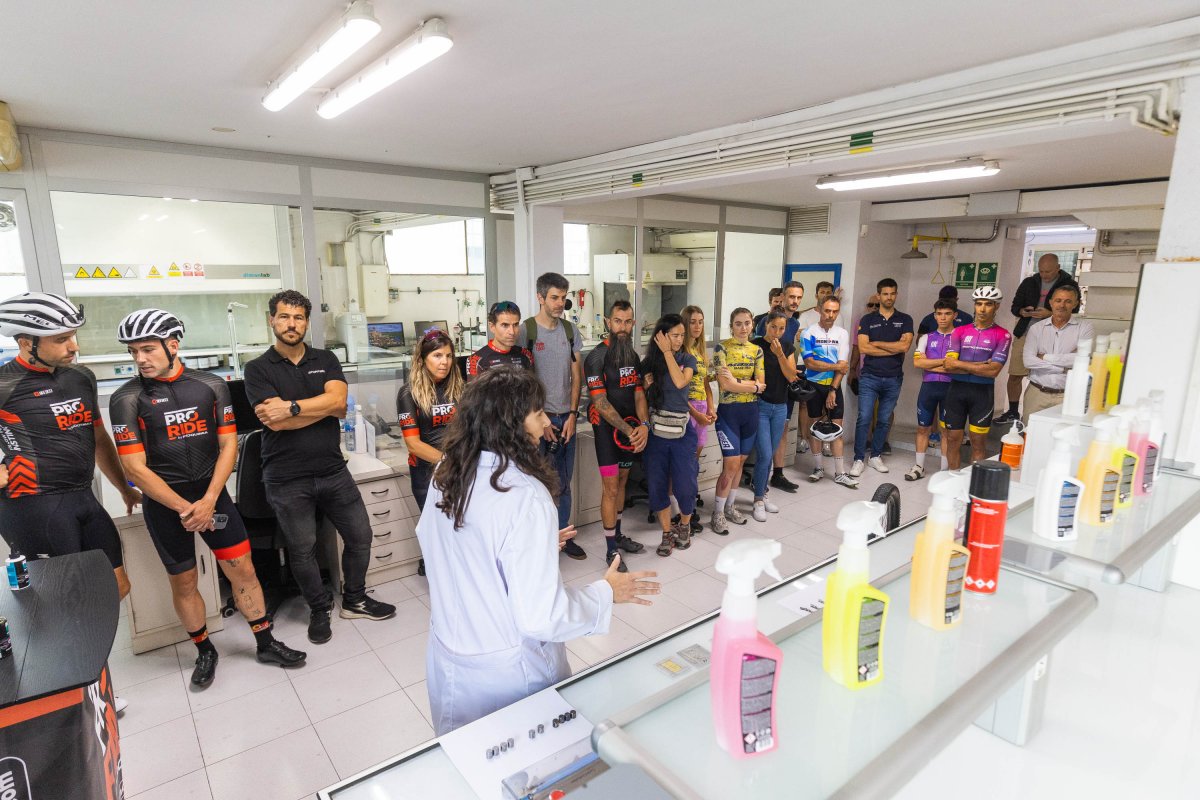 Els ambaixadors de la marca ciclista atenent les explicacions de Marta Comas al laboratori de Proquimia