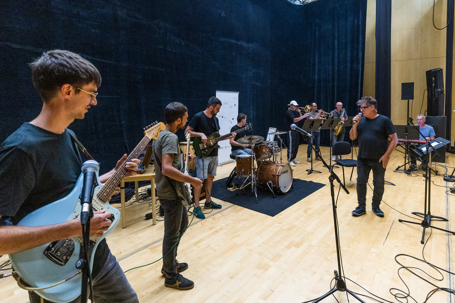 Una part dels components d’Est Oest preparant el tema que interpretaran en el concert davant de Joan Godayol, ‘Gudi’. Al fons, als teclats, Marc Vernis