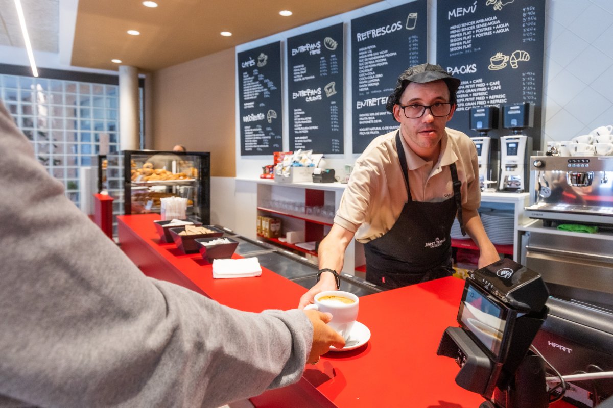 Vilardell servint un cafè amb llet el primer dia de funcionament de la nova cafeteria