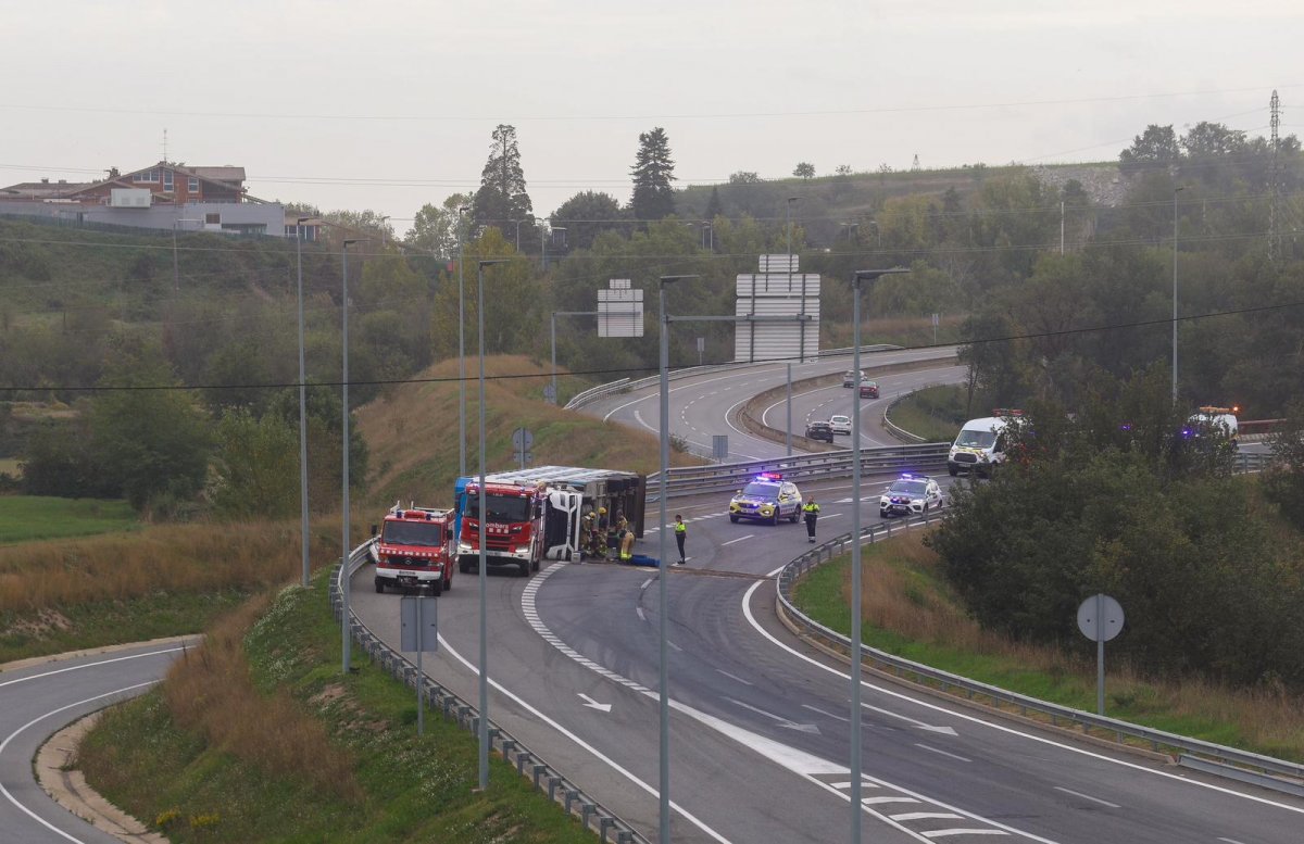 El camió bolcat a la C-25, amb Bombers i Mossos treballant-hi