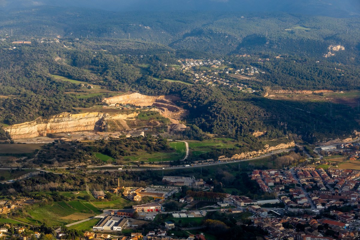 Les pedreres de Seva, amb la del Fitó, que encara està en actiu, a l'esquerra, i l'antiga de Sant Antoni del Pinós, a la dreta, amb Can Garriga al mig, vistes des del Puigsagordi