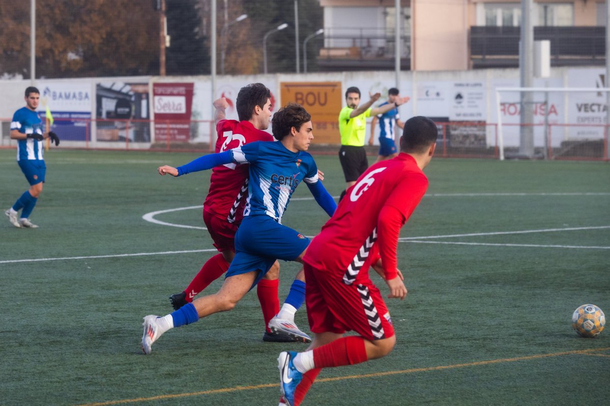 Biel Caballeria, envoltat de dos jugadors visitants