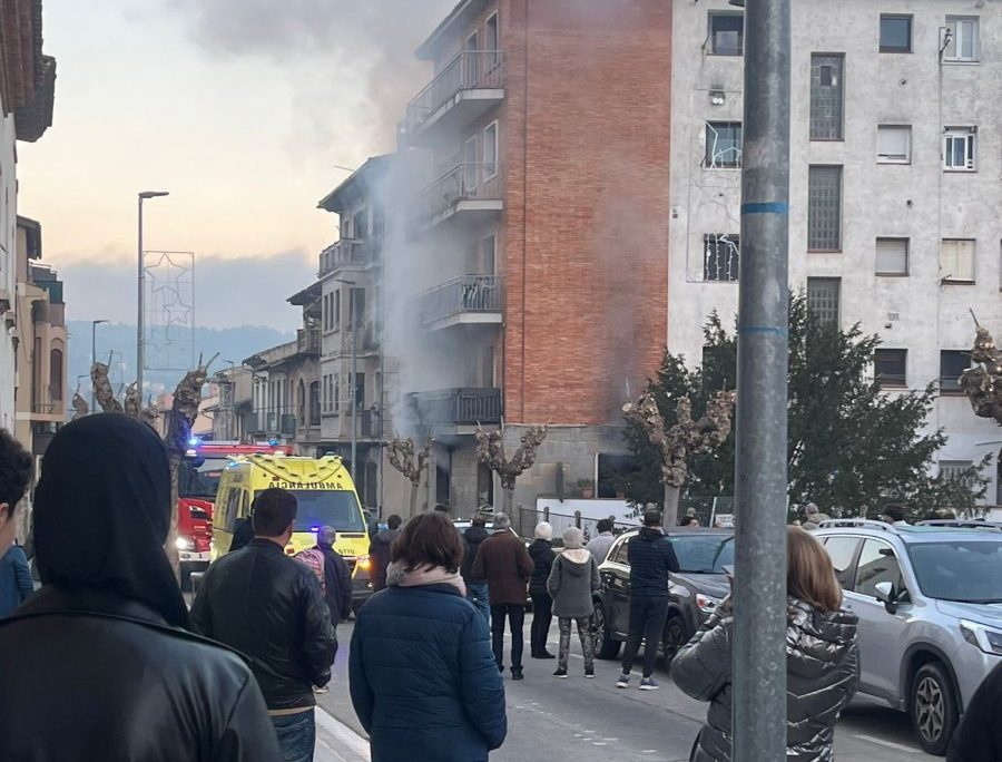 Veïns veient com treballen els Bombers al lloc de l'incendi