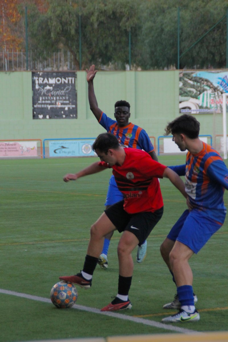 El jugador torellonenc Cañero, autor del segon gol del partit, envoltat de dos jugadors locals