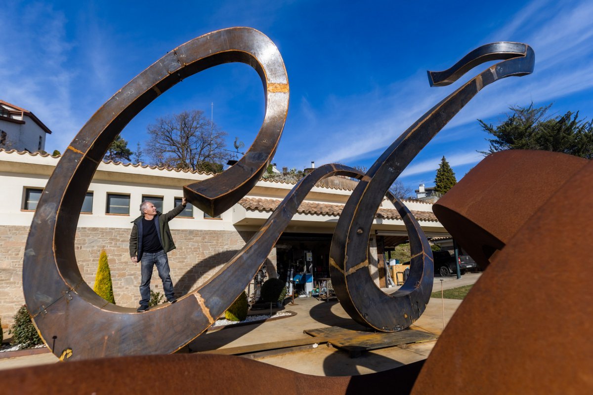 Enric Pla Montferrer davant del seu taller i ‘dins’ de l’escultura, en una imatge que permet fer-se càrrec de la magnitud de la ‘Bicicleta’