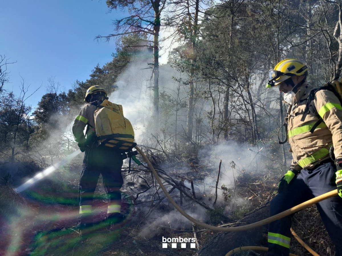 Els Bombers, treballant en l'extinció del foc