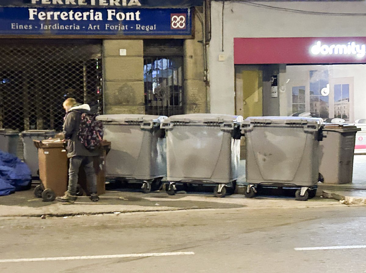 Una persona remenant en un contenidor al centre de la ciutat, dimarts