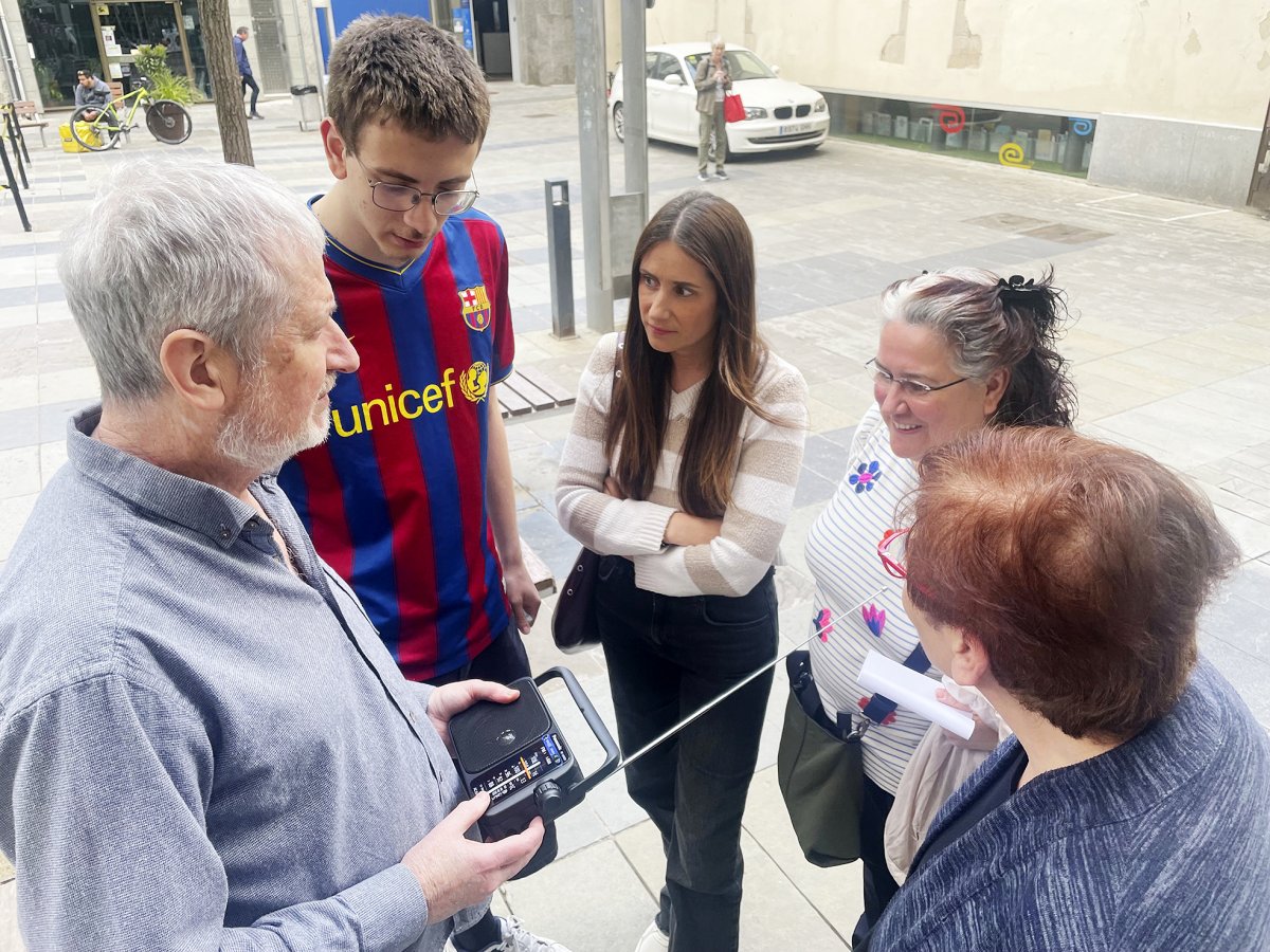 Treballadors i clients de la Ferreteria Canal de Granollers seguint l'apagada per la ràdio