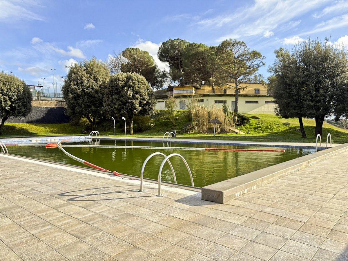 Vista de les piscines i de l'edifici que s'enderrocarà, en una imatge d'aquest abril