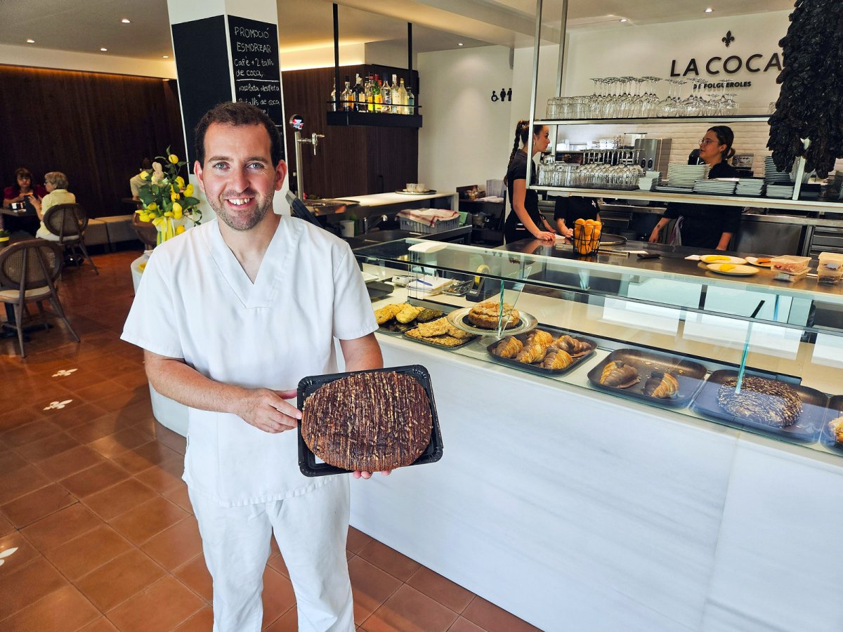 Marc Pascuet, mostrant la coca de Sant Joan que ha estat premiada, dimecres a la botiga i restaurant que tenen al polígon de Folgueroles
