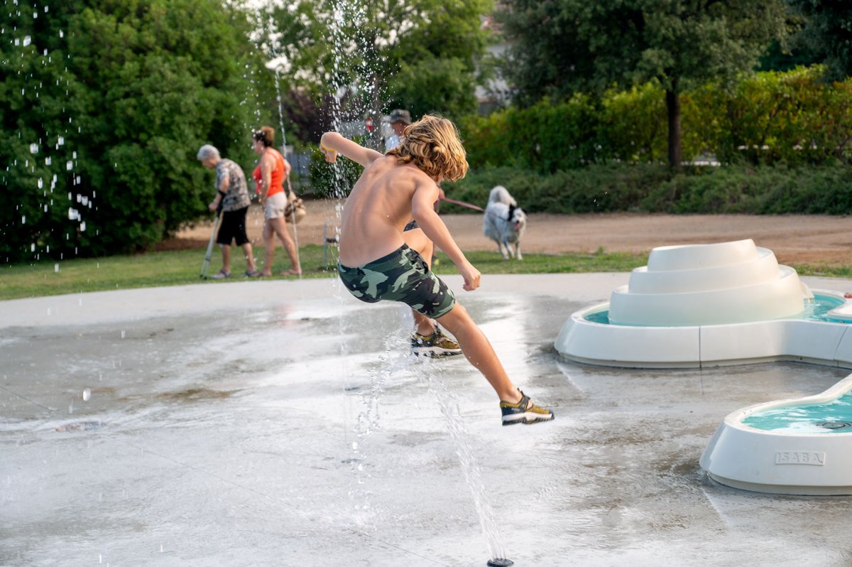 Un nen juga amb unes de les fonts d’aigua que hi ha a l’Ametlla aquesta setmana